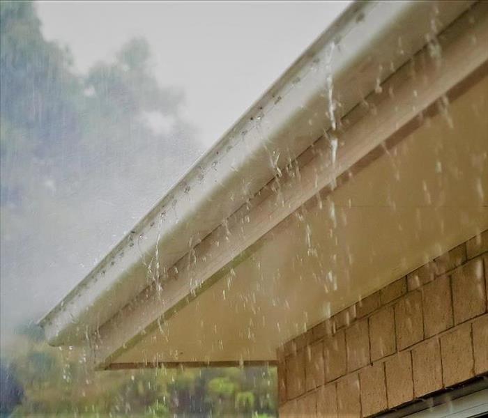 Heavy rain hitting the roof of a home and the home’s rain gutters.  